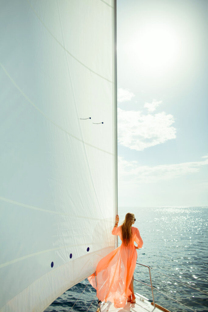 woman in sarong yachting white sails luxury travel